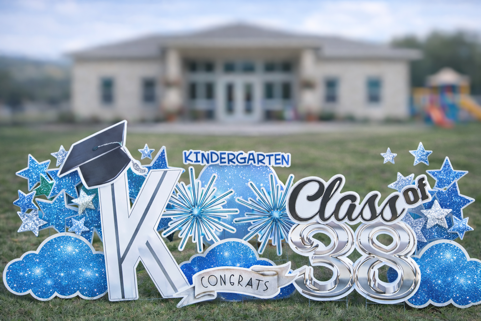 Kindergarten graduation yard card display with blue stars and Class of 38 signage